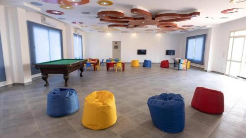 a room with a pool table and some chairs at Oyster Bay Beach Suites in Marsa Alam