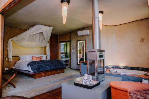 a bedroom with a bed and a tub in it at Forum Homini Boutique Hotel in Krugersdorp