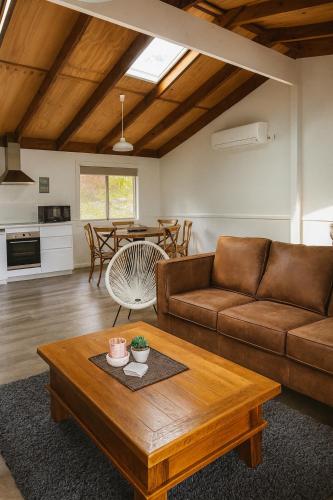 a living room with a couch and a table at Cocora Beach Cottage - pet friendly in Eden