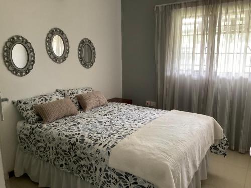 a bedroom with a bed and two mirrors on the wall at Ginnys Place in Gaborone