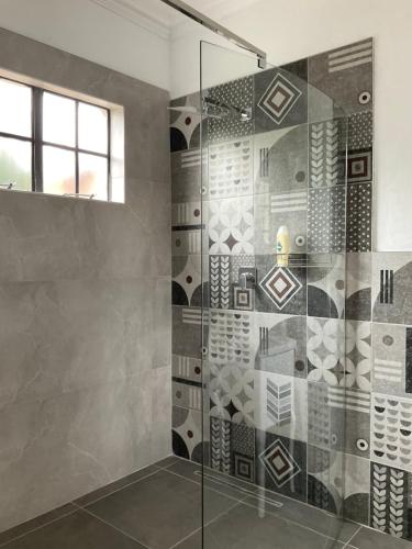 a bathroom with a shower with a glass door at Ginnys Place in Gaborone