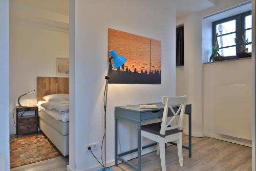 una camera da letto con scrivania e letto con lampada di Ohlerich Speicher App_ 12 a Wismar