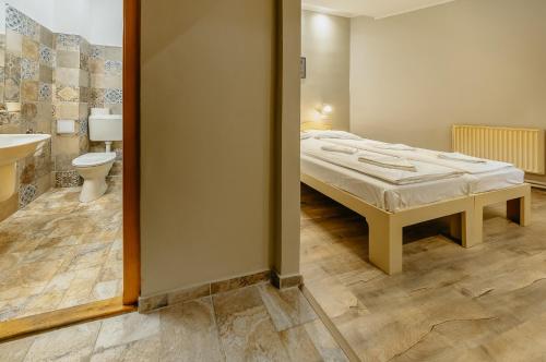 um quarto com uma cama e um banheiro com vaso sanitário em Hostel Teleki em Sovata