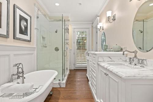 um banheiro com duas pias, uma banheira e um chuveiro em Malibu Dunes by Fieldtrip Expansive Hamptons-Style Estate w Private Beach Backyard em Malibu