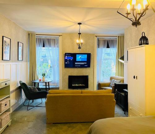 uma sala de estar com um sofá e uma TV em Carvetii - Abbey View, 1st Floor Flat, City Centre em Dunfermline