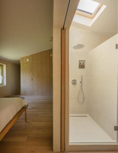 a bedroom with a shower with a glass door at Casa Mínima retiro Passivhaus in Selaya