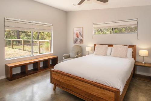 a bedroom with a large bed and two windows at Sequoia Sanctuary - Margaret River in Margaret River Town