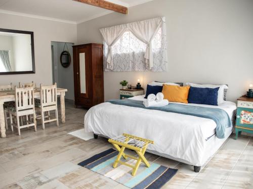 a bedroom with a large bed and a table at Bluewater Guesthouse in Port Elizabeth