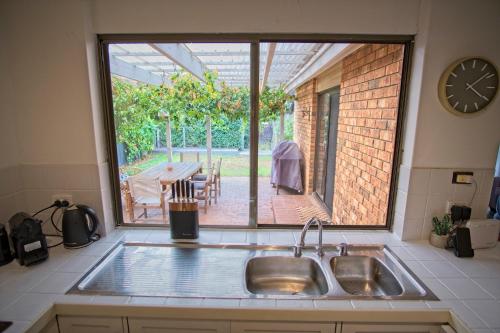 Goolwa SouthDelight On Downer - Coastal Family Escape的一个带水槽的厨房,享有庭院的景色