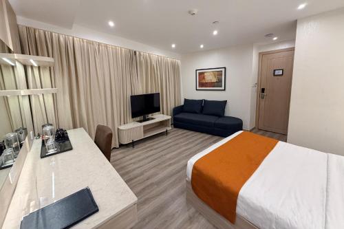 um quarto de hotel com uma cama e um sofá em City Garden Hotel Makati em Manilla