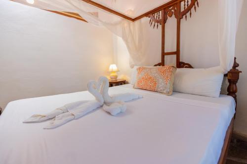 a bed with two stuffed animals on it at Silver Residence Apartments by MOKAWA in Malindi