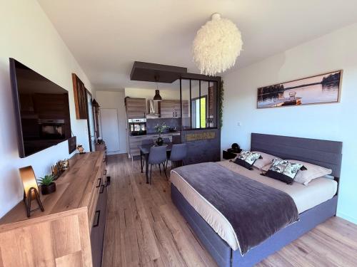a bedroom with a large bed and a dining room at Studio cosy au Crêt du Chardon in Chambost-Allières