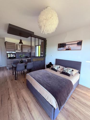 a bedroom with a large bed and a dining room at Studio cosy au Crêt du Chardon in Chambost-Allières