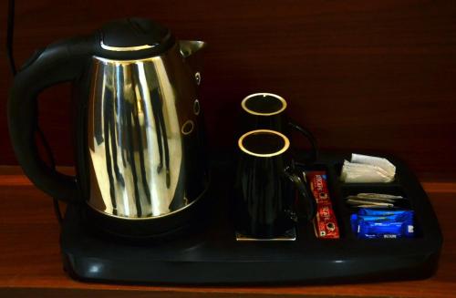a black tea kettle sitting on a black tray at 4Everstay By Prem Ratan Premium Rooms With Free Parking & Wifi !!! Best Family Hotel In Vrindavan in Vrindāvan