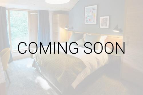 AmpthillThe White Hart的一间白色的卧室，床上写着“即将推出”的字样。