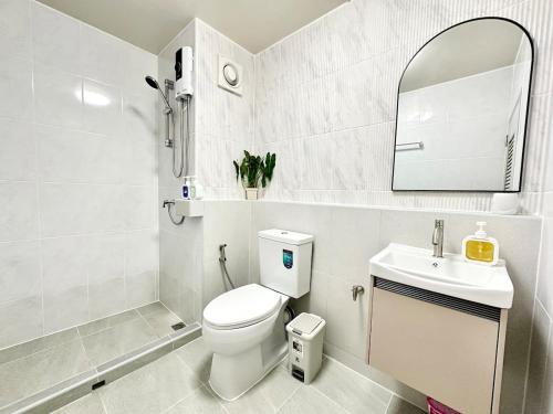a bathroom with a toilet and a sink and a mirror at Lykke Room Poppular Condo P1 in Ban Bang Phang