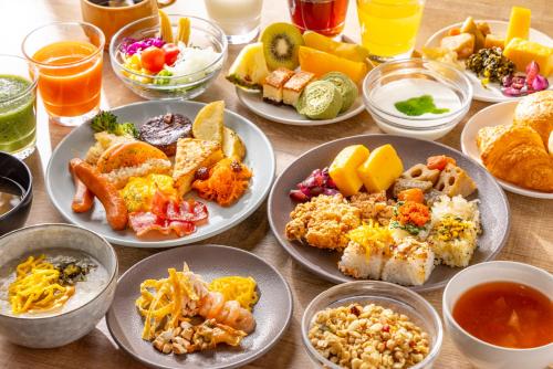 a table filled with plates of food and drinks at Tokyu Stay Shinjuku Eastside in Tokyo