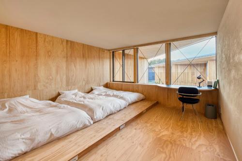 a bedroom with two beds and a desk and a chair at SANU 2nd Home Ichinomiya 2nd in Ichinomiya