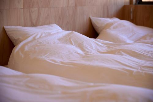 an unmade bed with white sheets and pillows at SANU 2nd Home Ichinomiya 2nd in Ichinomiya