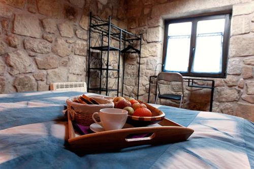 a tray with a basket of fruit on a bed at Huerto San Antonio in La Cabrera