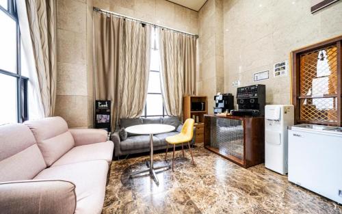 首尔Jardin Hotel的客厅里有一张沙发和一张桌子。
