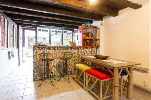 cocina con barra con taburetes y mesa en Suítes no Centro Histórico de Paraty, en Paraty