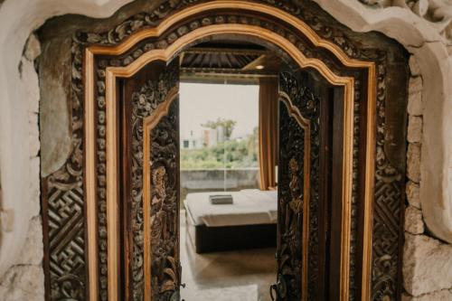 an ornate mirror in a room with a bed at Uluwatu Mansion Villas in Uluwatu