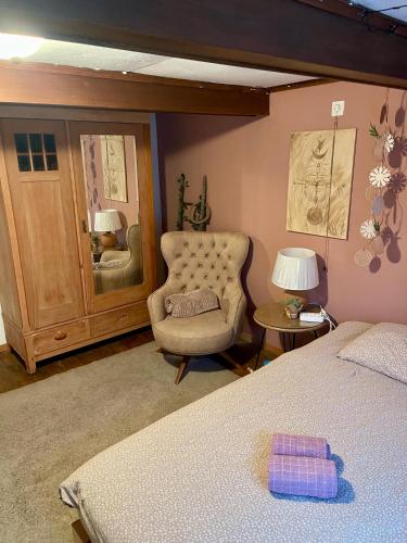 a bedroom with a chair and a bed at Cozy Room in an old Farmhouse near Vaduz in Sevelen