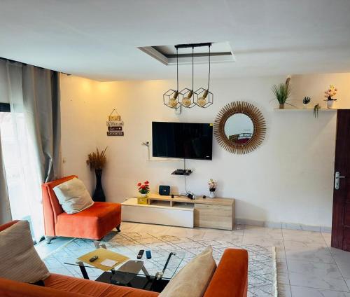 Una sala de estar con un sofá y un televisor. en Résidence Karima, en Abiyán