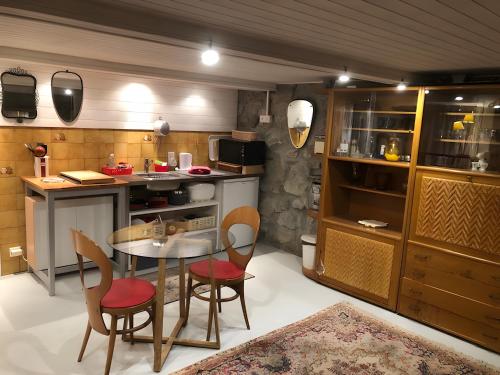 una cucina con un tavolo e sedie in una stanza di Le Carnotzet Du Lac - Hauts D'evian a Larringes