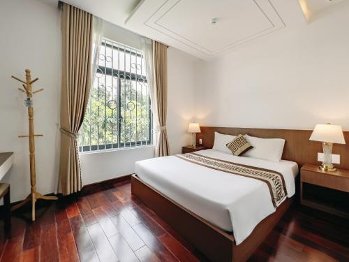 Phú MỹSao Mai Phú Mỹ Resort的一间卧室，配有一张大床和一扇窗户。