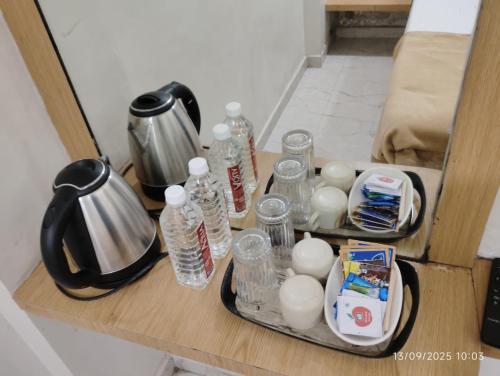 a counter with bottles of water and a kettle at Hotel Sai Pratham in Shirdi