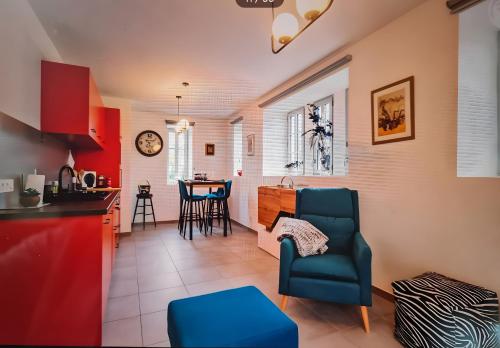 a kitchen and living room with a chair and a table at Location Appartement Les Ondes in Albertville
