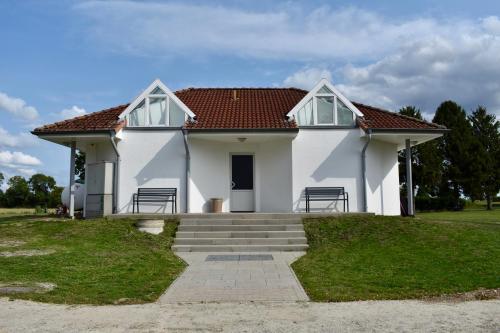 Campingfass im Naturresort Weserinsel في Langwedel: بيت أبيض بسقف أحمر