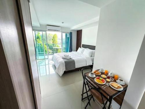 a bedroom with a bed and a table with food on it at Sea saran Condominium - Modern & nature Studio in Bang Sare
