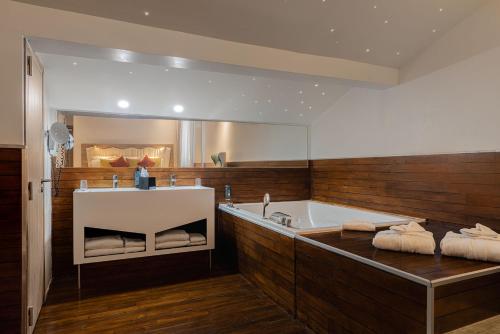 モンペリエにあるベスト ウエスタン プラス コメディ サンロッシュの大きなバスルーム(バスタブ、大きな鏡付)