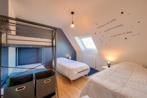 a bedroom with two bunk beds and a window at Maison pour 6 avec grand jardin - proche centre in Plouguerneau