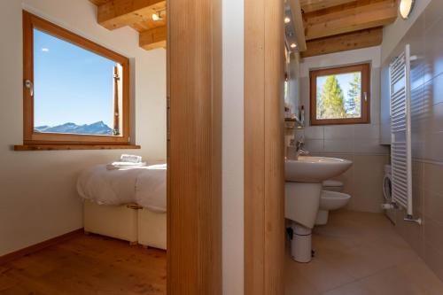 a bathroom with a sink and a toilet and a window at Wonderful appartment Monte Civetta in Dolomites in Alleghe