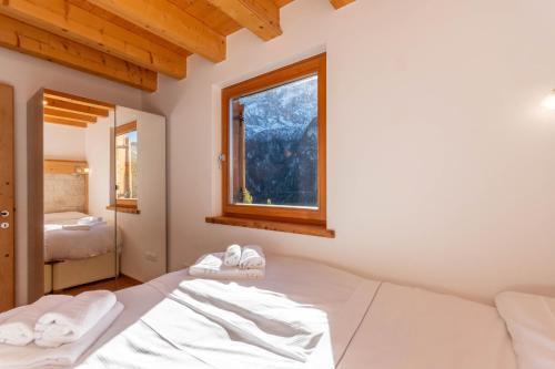 a bedroom with a bed and a window at Wonderful appartment Monte Civetta in Dolomites in Alleghe