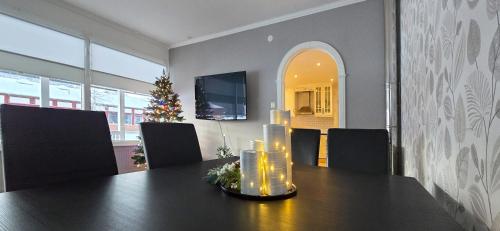 a dining room with a table with candles and a christmas tree at Hus Klarälven in Stöllet