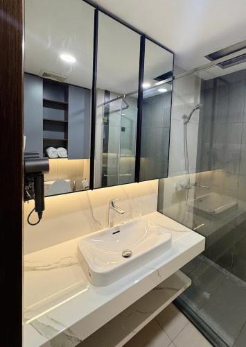 a bathroom with a sink and a shower at Cozy modern studio with Gym & Pool in Hanoi