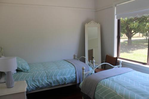 een slaapkamer met een bed, een spiegel en een raam bij Nonna's Cottage 