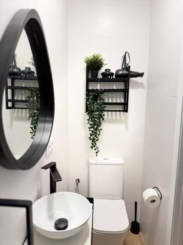 ein Badezimmer mit einer weißen Toilette und einem Spiegel in der Unterkunft Apartamento Mamalú Jerez in Jerez de la Frontera
