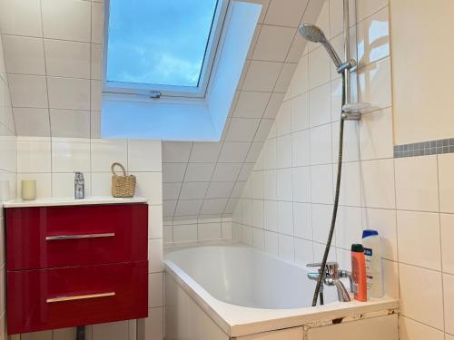 une salle de bain avec une baignoire et une fenêtre dans l'établissement La Terrasse du Havre, au Havre