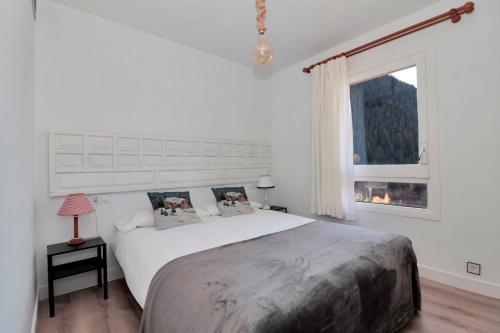a white bedroom with a large bed and a window at Apartarent 1500 - Apartamento Sanglier in Naut Aran