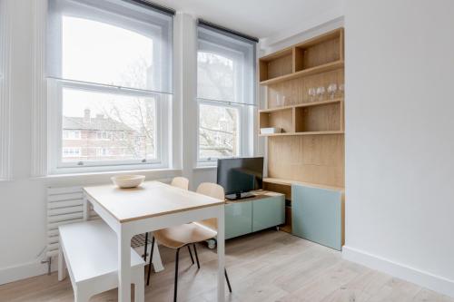 a room with a desk and a computer and two windows at Live like a Londoner by TOWER BRIDGE in London