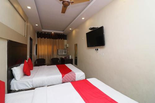 a hotel room with two beds and a flat screen tv at Super Hotel O by OYO Surya Continental in Lucknow