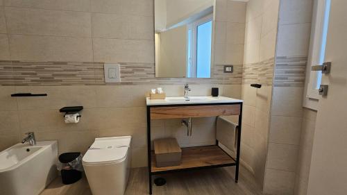 a bathroom with a sink and a toilet and a mirror at Talenti Suites Rome Casa Vacanze in Rome