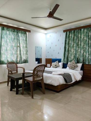 a bedroom with a bed and a table and chairs at Hotel Shree Maya Inn in Vadodara