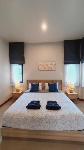 a bedroom with a large bed with blue pillows on it at Samati Hill - Sunset Pool Villa 6 - Klong Ning Beach in Ko Lanta Yai